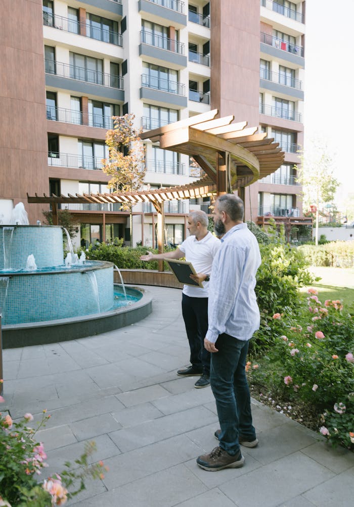 Two architects evaluating a modern residential complex with a fountain and garden in Istanbul.
